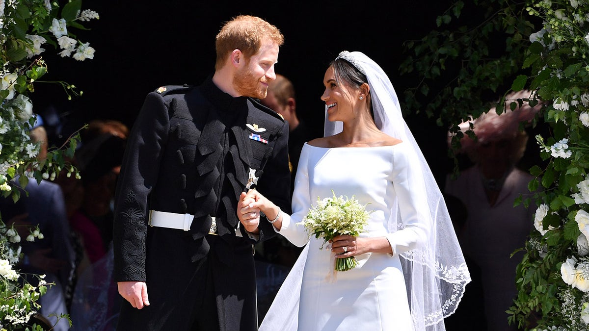 Meghan Markle in her bridal gown smiling at Prince Harry on her wedding day.