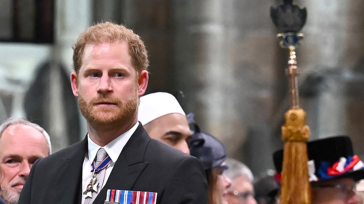 Prince Harry inside a church wearing a suit with his medals.