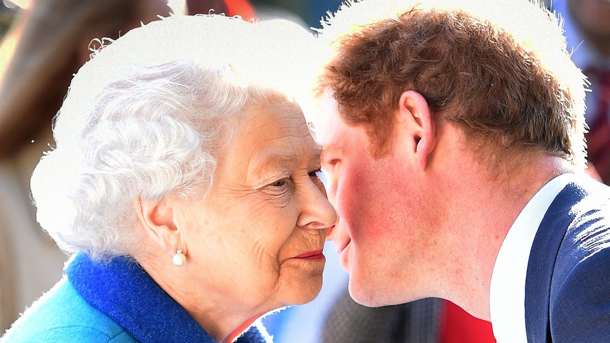 Queen Elizabeth II receiving a kiss from Prince Harry.