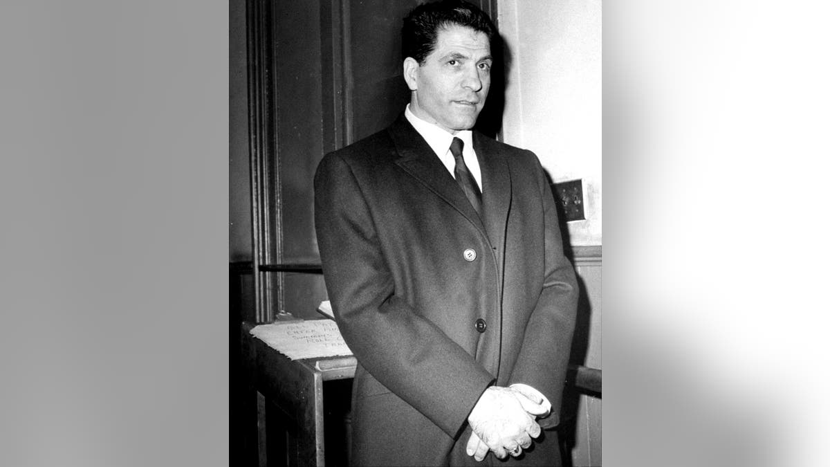 Sonny Franzese wearing a suit holding his hands.