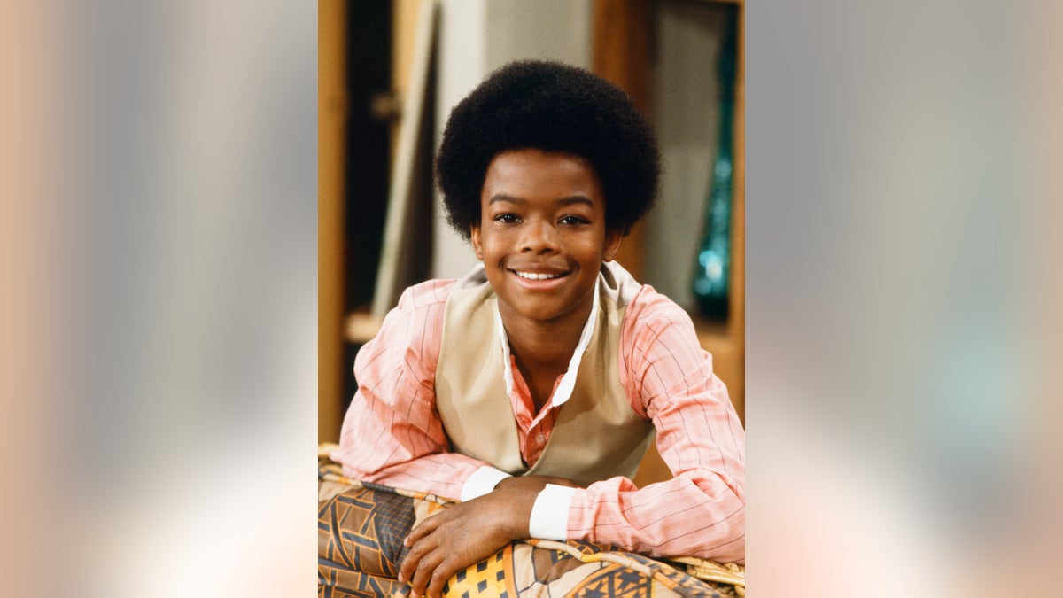 A young Todd Bridges smiling on set.