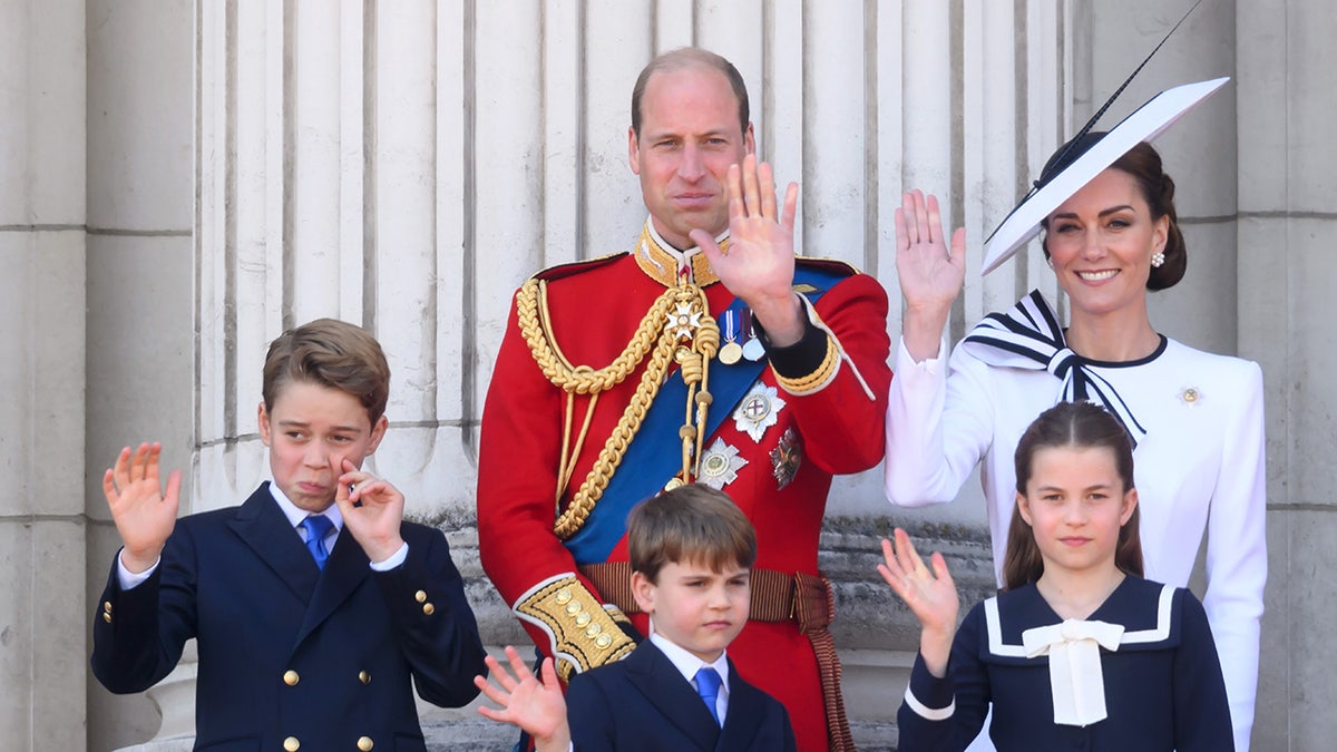 El príncipe Guillermo de rojo, Kate Middleton de blanco y sus tres hijos saludan desde el balcón del Palacio de Buckingham