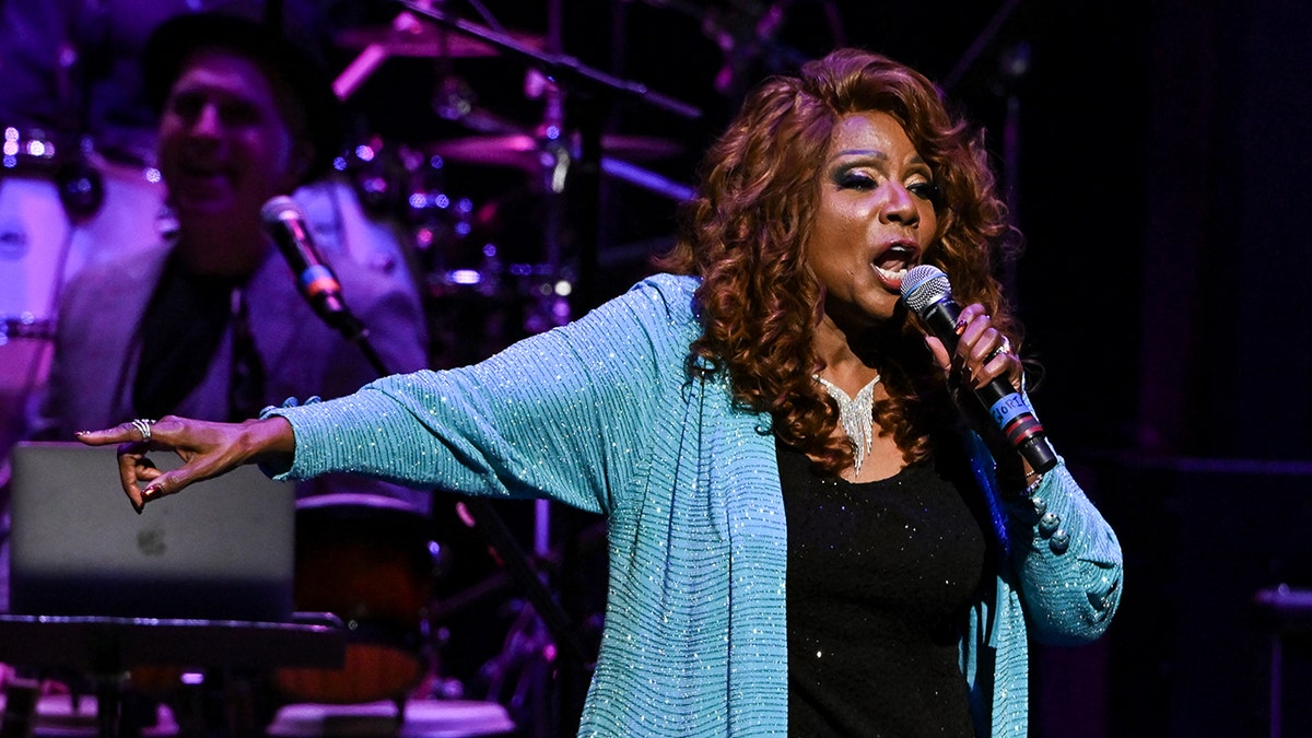 Gloria Gaynor singing in front of the microphone