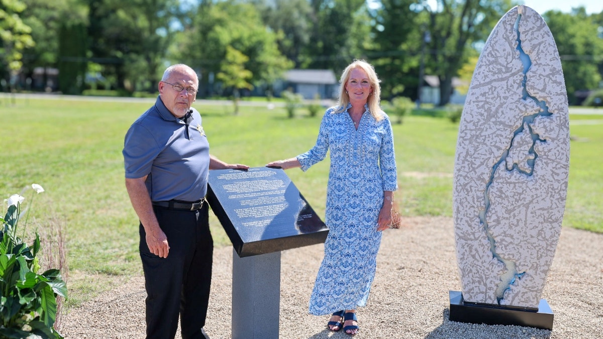 Jeff Jellison y Linda Znachko junto al monumento conmemorativo de la Granja Fox Hollow