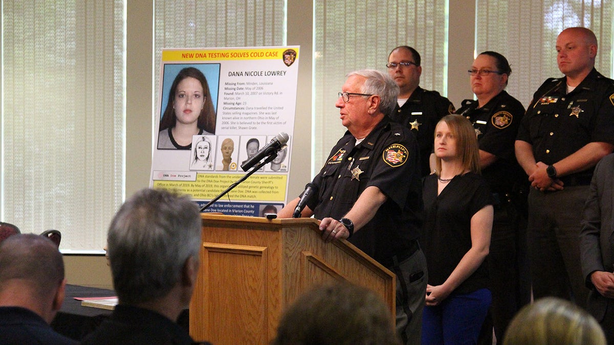 Police speaking at a press conference next to a photo of Dana Lowrey.