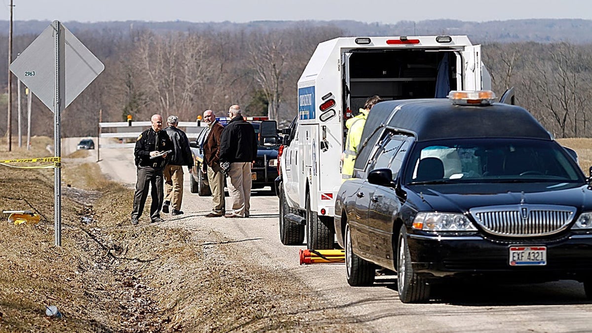 Police investigating a road where a victims body was discovered.