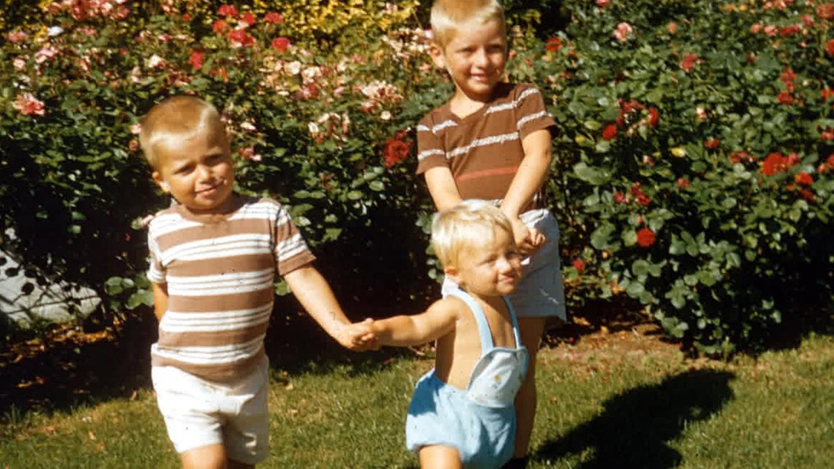 The Hadden brothers hold hands and play.