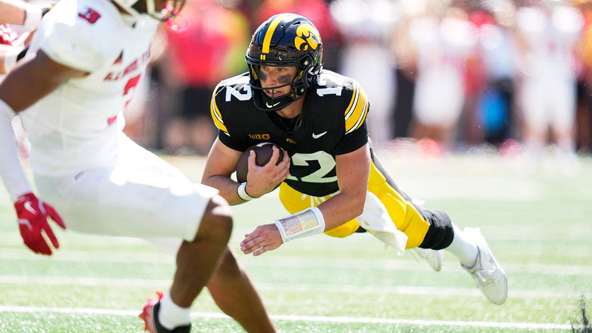 El quarterback de Iowa corre con el balón