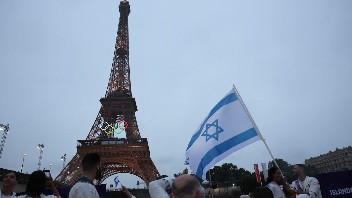 Athletes of Israel look on as the Eiffel Tower is seen.