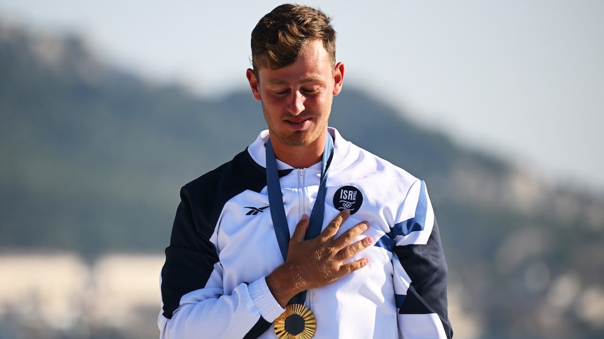 Tom Reuveny da equipe Israel comemora a conquista da medalha de ouro