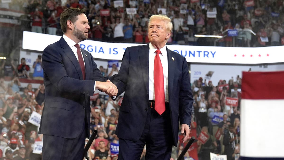 GOP running mate Sen. JD Vance of Ohio ,left, greets Republican presidential nominee and former President Donald Trump during at a campaign rally at Georgia State University in Atlanta, Saturday, Aug. 3, 2024. (AP Photo/John Bazemore)