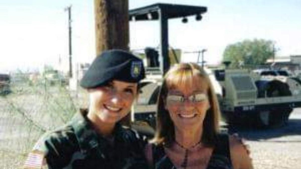 Jennifer Horn in an Army uniform posing with her mother wearing glasses and smiling