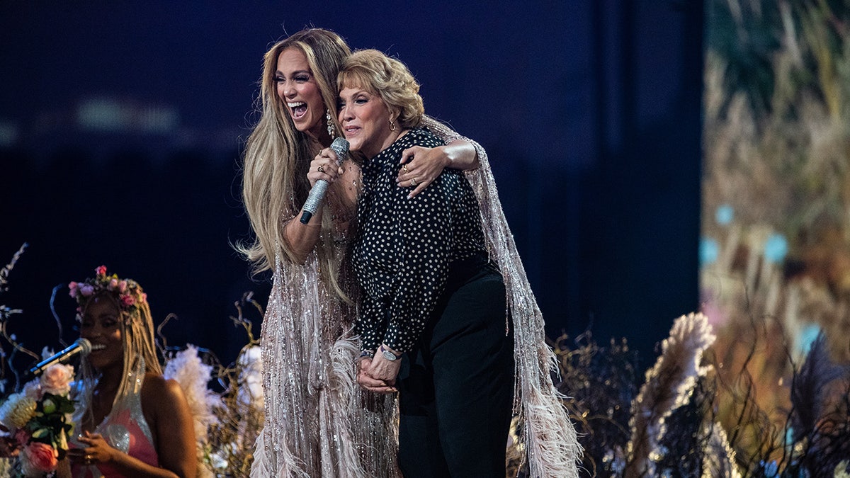 Jennifer Lopez con el brazo alrededor de su madre Guadalupe en el escenario