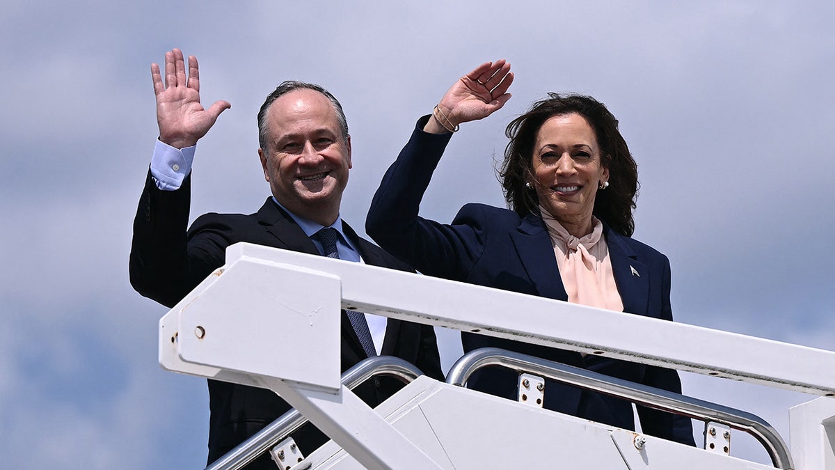 La vicepresidenta de EE.UU. y candidata demócrata a la presidencia en 2024, Kamala Harris, y el segundo caballero Doug Emhoff saludan al subir al Air Force Two