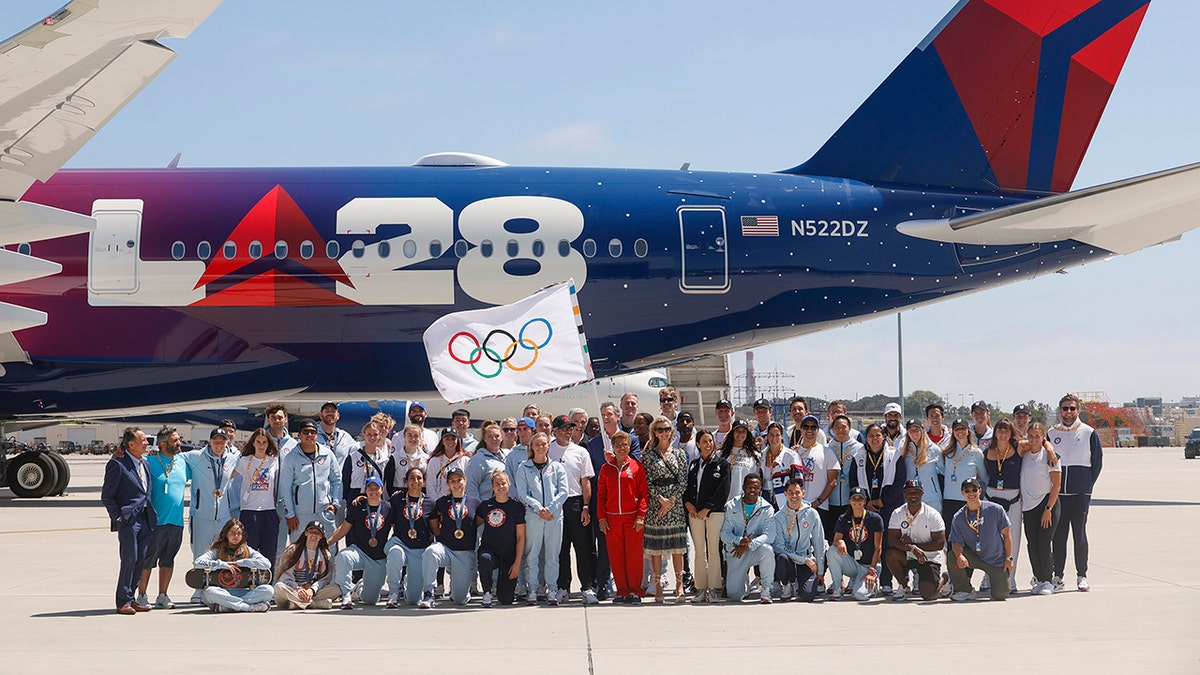 Karen Bass ondea la bandera con el contingente alrededor del avión