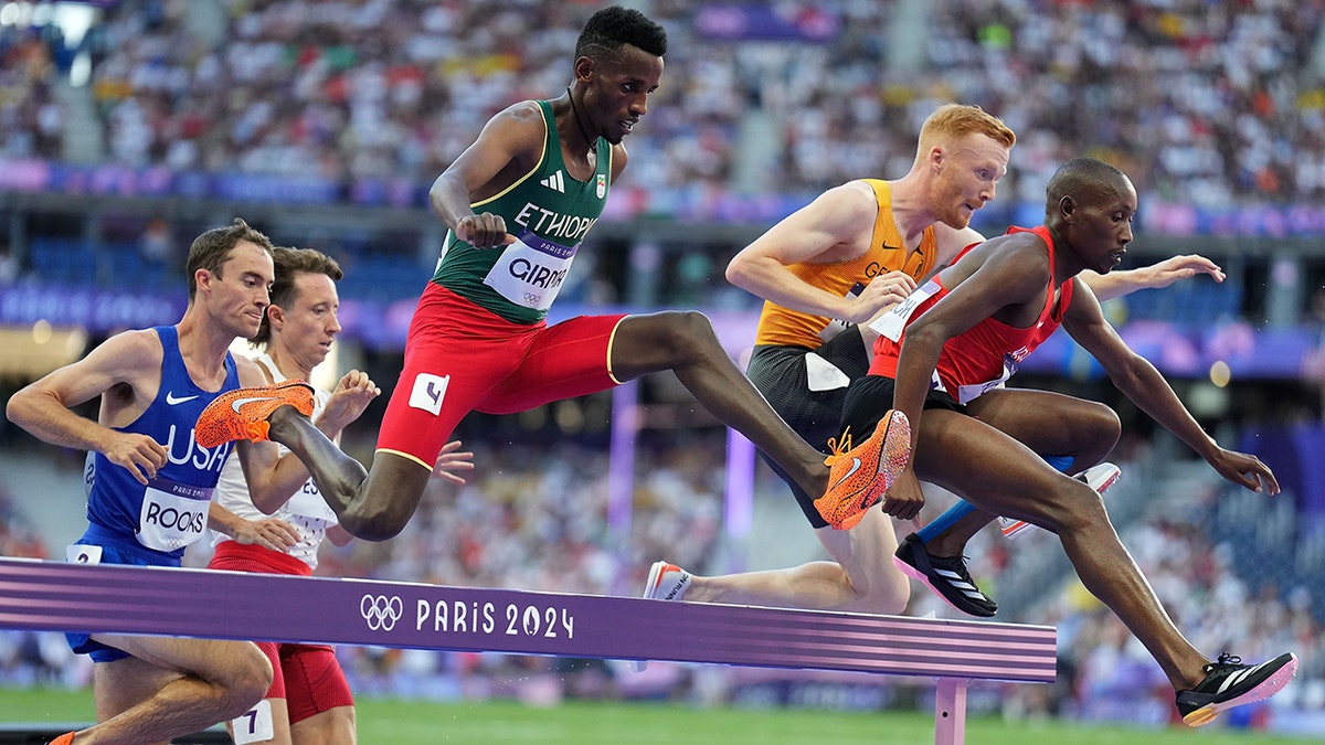 Lamecha Girma jumps over an obstacle