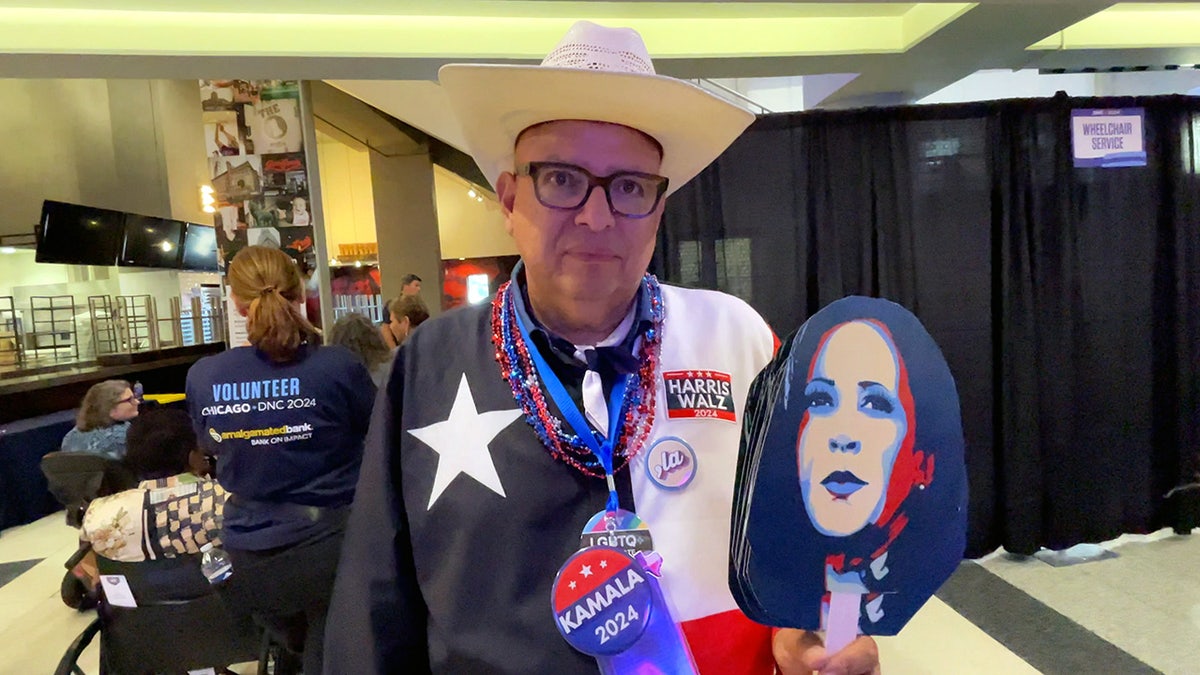 Texas delegate Luciano Garza holds cutouts of VP Kamala Harris' face