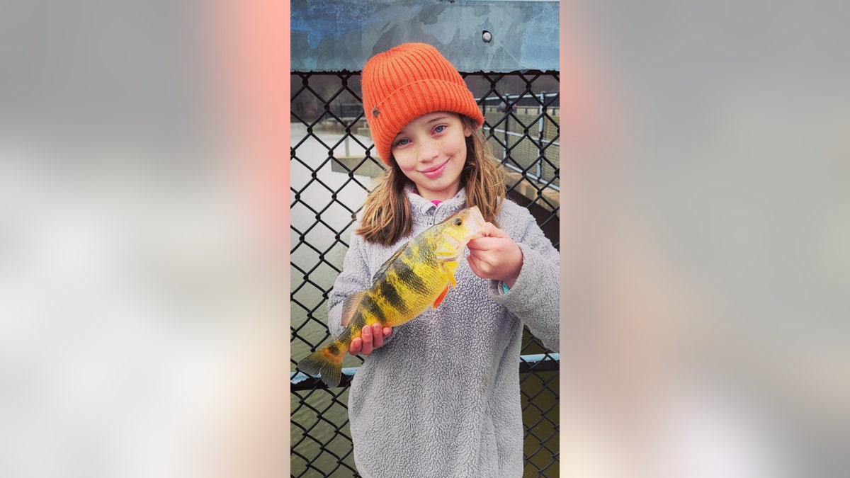 Lucy-segurando-peixe-amarelo