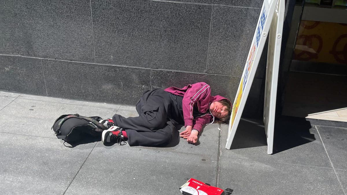 A man lies on the street in San Francisco.