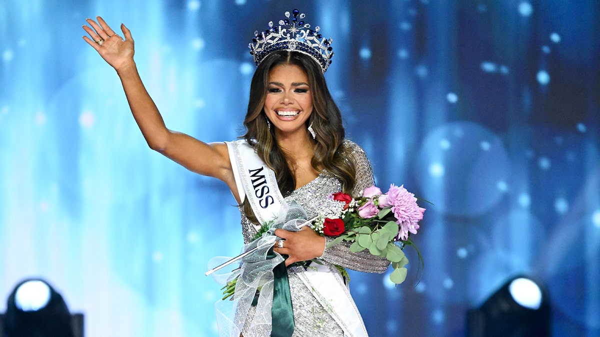 Alma Cooper con la corona de Miss USA y saludando