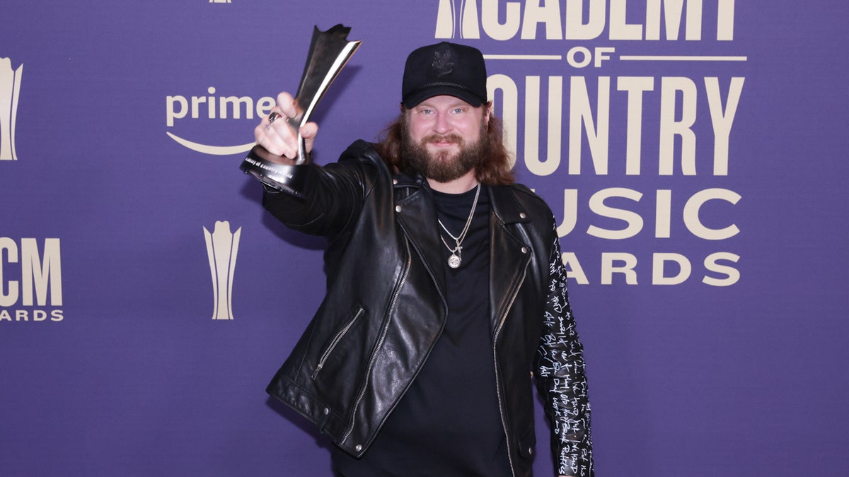 Nate Smith holds up an award