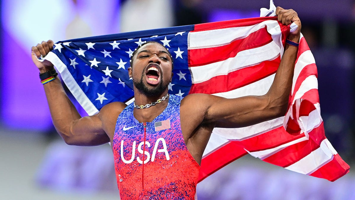 Noah Lyles con la bandera estadounidense