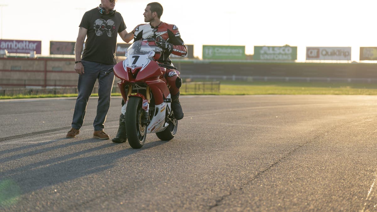 eric dane putting his hand on kj apas shoulder while apa sits on a motorcycle