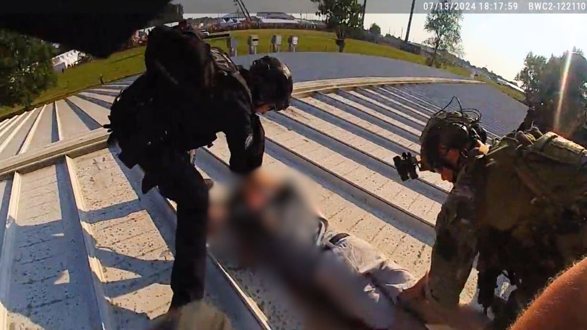 Police officers stand over the shooter Thomas Crooks