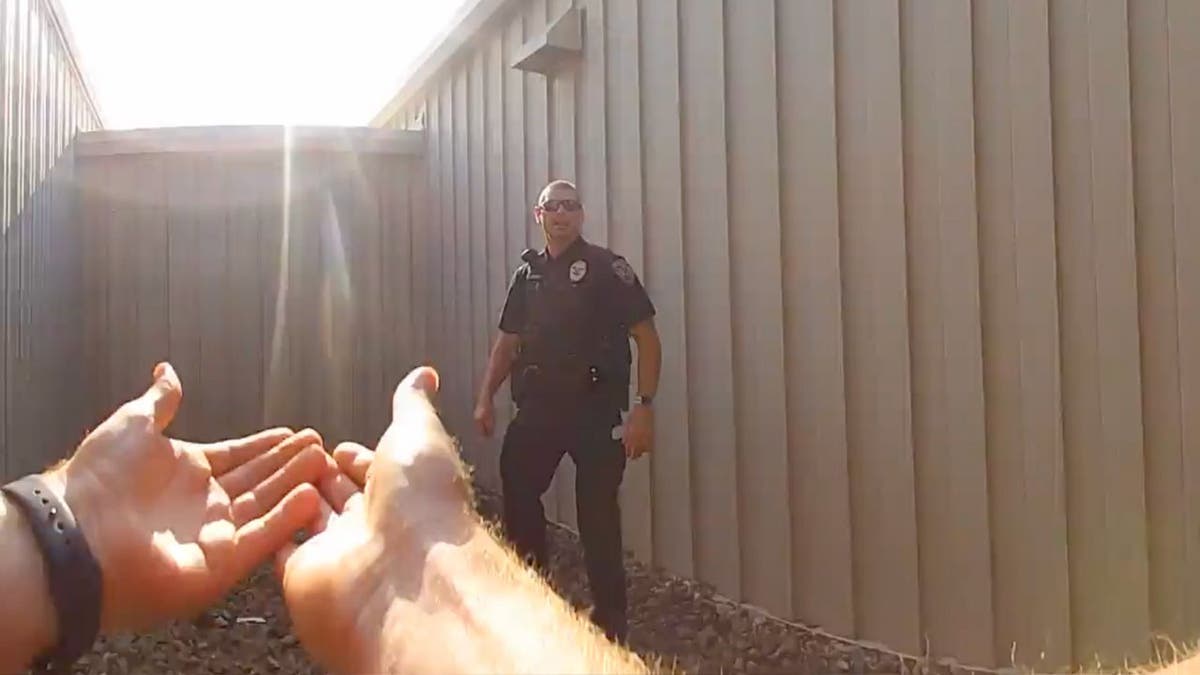 One officer indicates to hoist another officer onto a roof