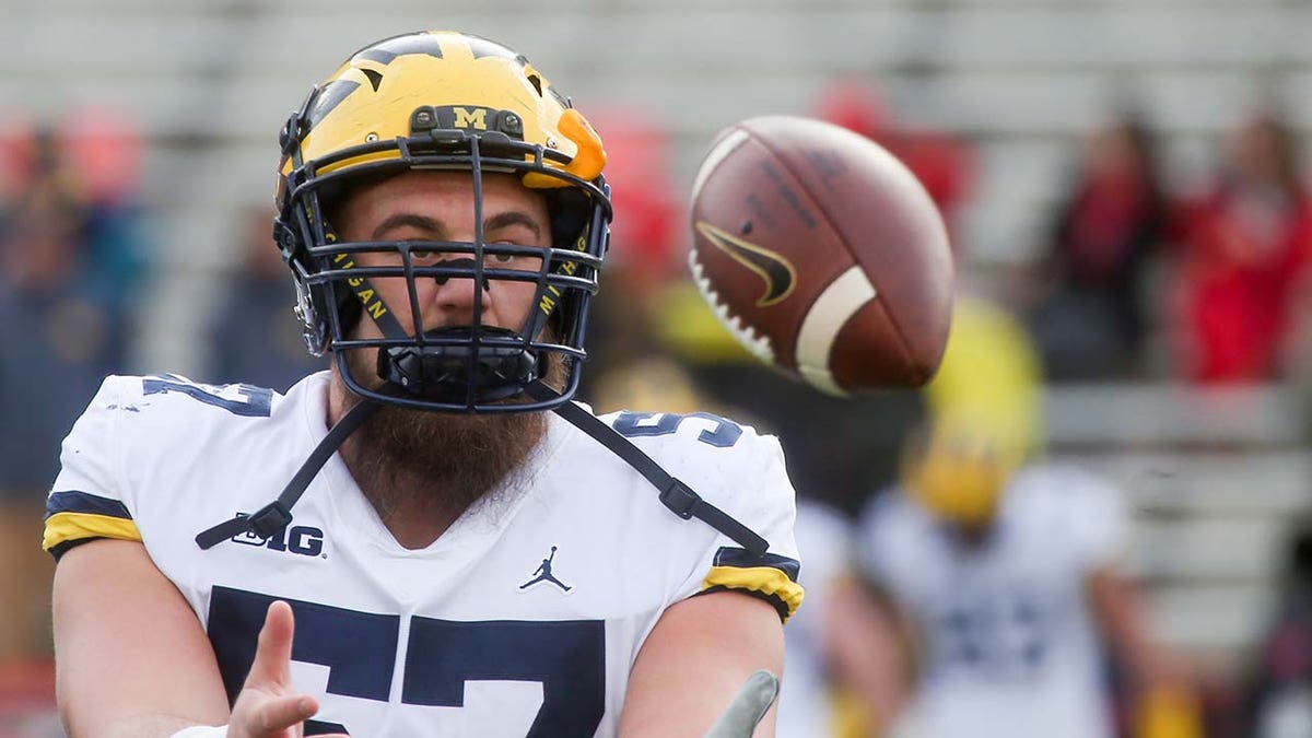 El liniero ofensivo de los Wolverines de Michigan, Patrick Kugler, observa antes de un juego