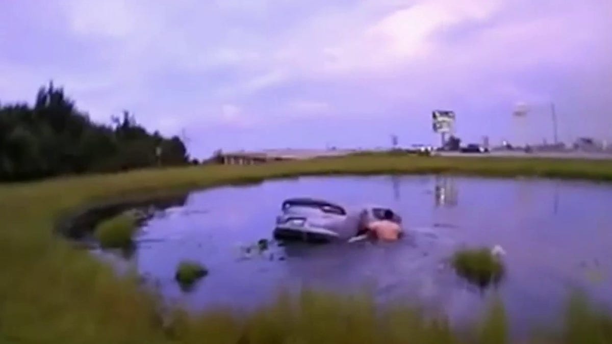 Car sunk in a lake, man tries to open right door.