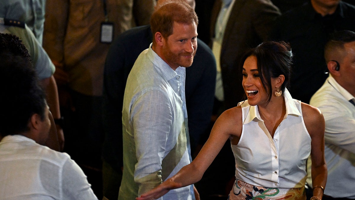 Prince Harry and Meghan Markle greeting people