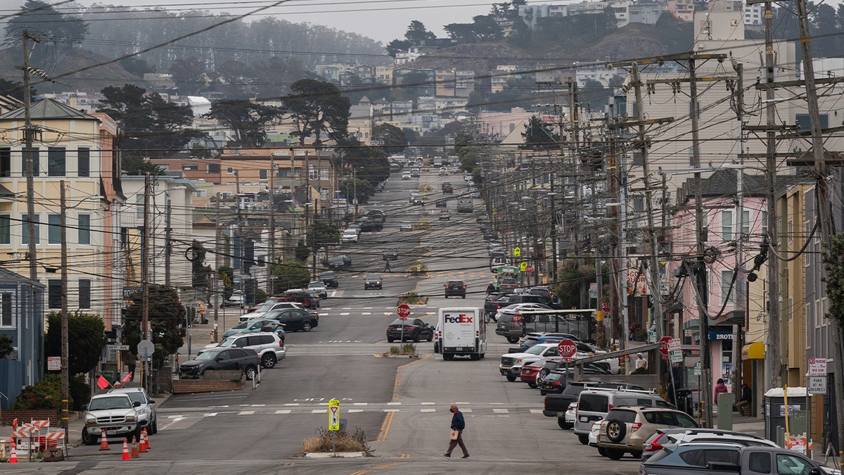 A pedestrian crosses a street in the Outer Sunset neighborhood near Ocean Beach in San Francisco on June 26, 2023.