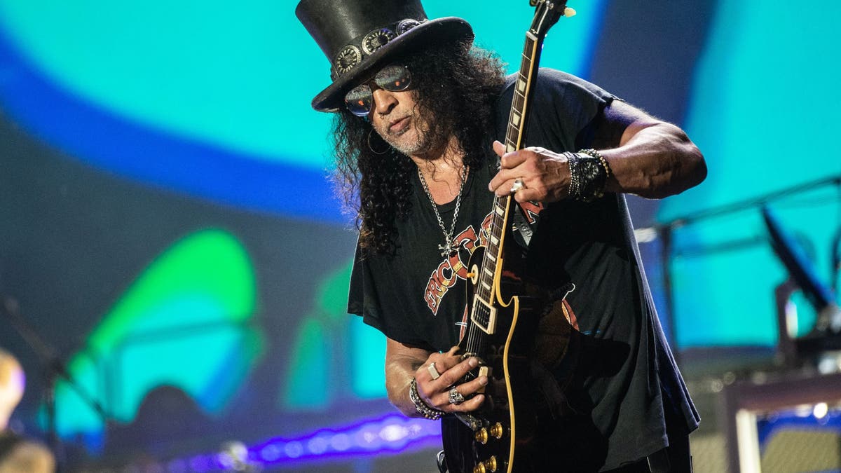 Slash di atas panggung dengan gitar