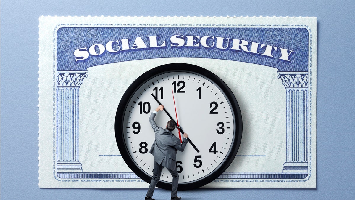 A man holds back the hands of time on a large clock that stands in front of a large Social Security card.