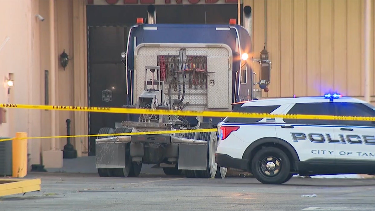 A view of the accident site with barrier tape and a patrol car