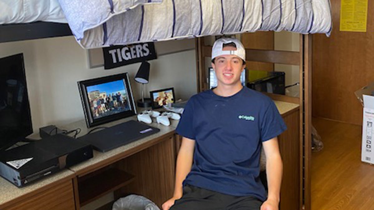 Danny Santulli sitting in his dorm smiling.