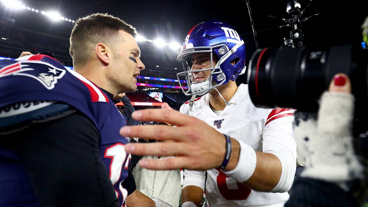 Tom Brady spricht mit Daniel Jones