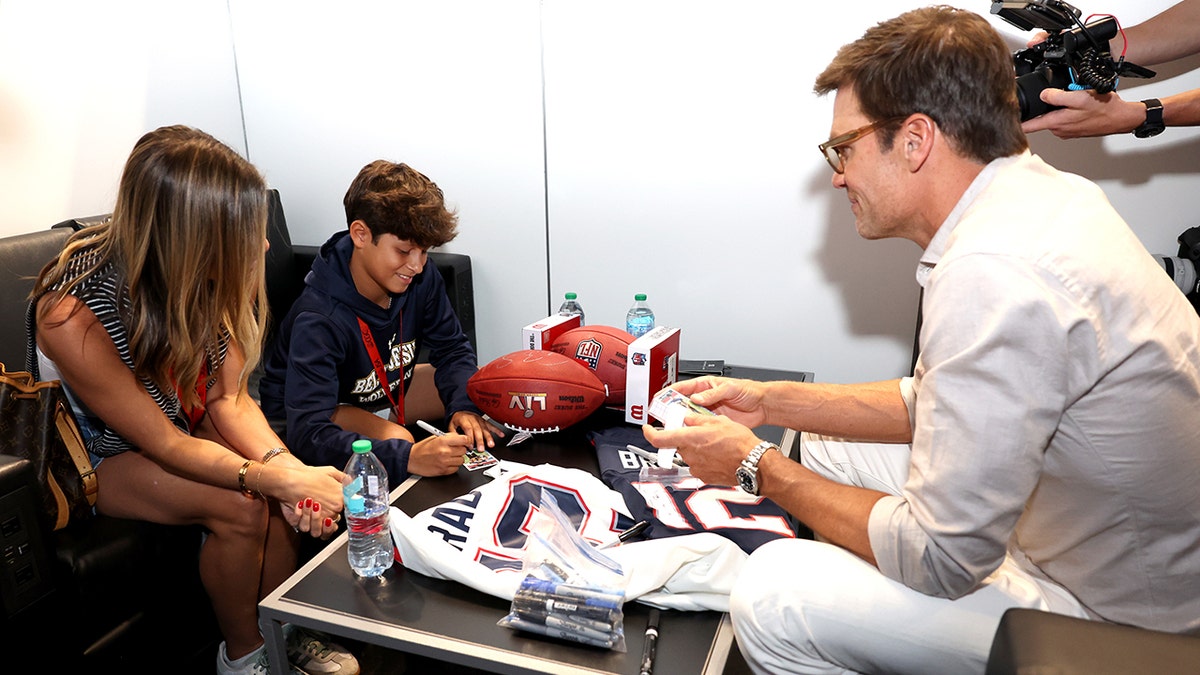 Tom Brady trades cards with Chris Sanchez