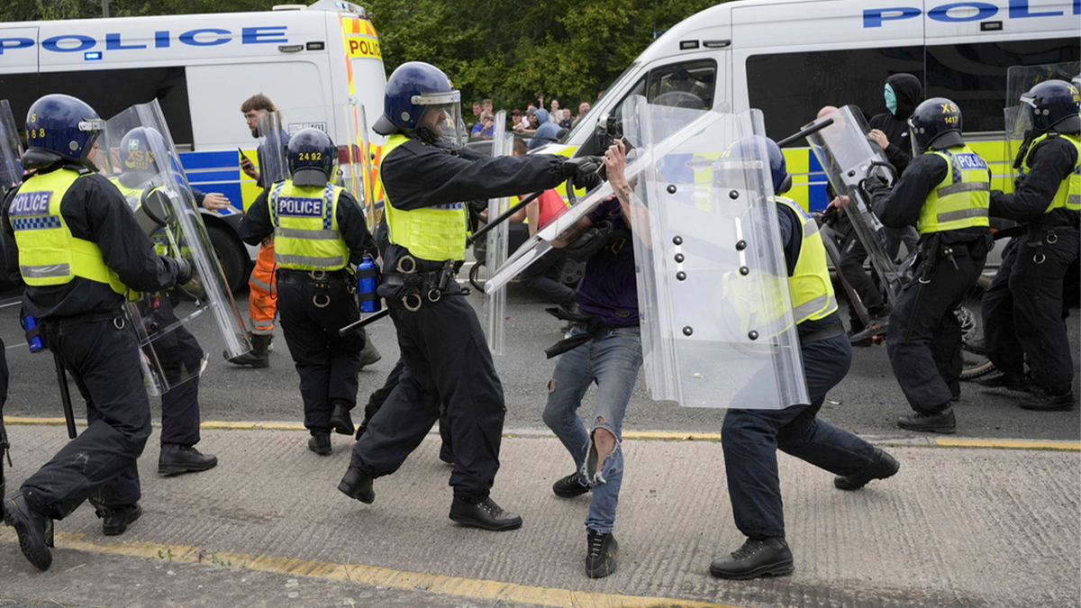 Police confront rioters in the UK