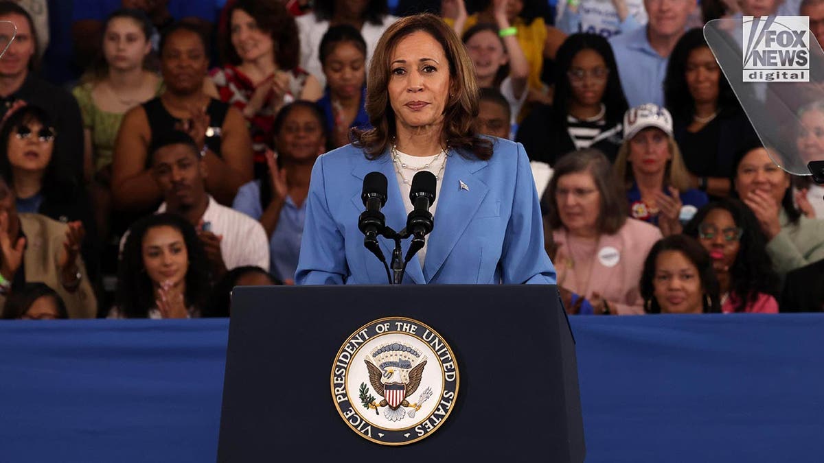 Vice President Kamala Harris stands at the podium in a blue suit