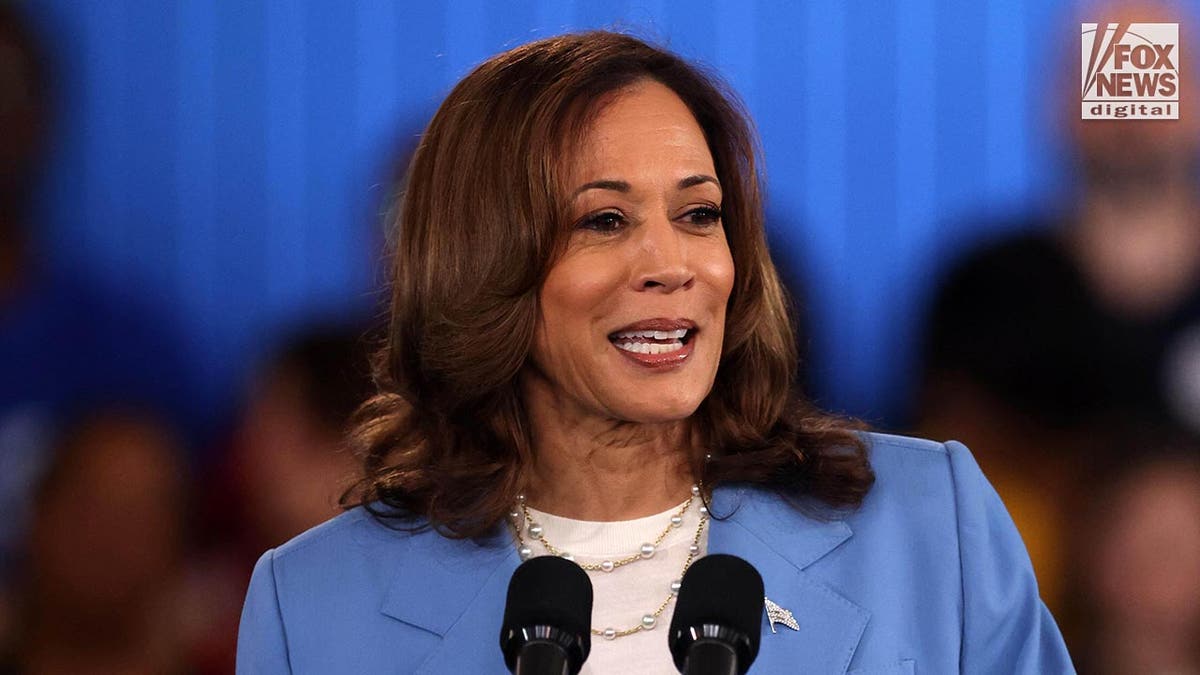 La vicepresidenta Kamala Harris, con un traje azul, sube al estrado