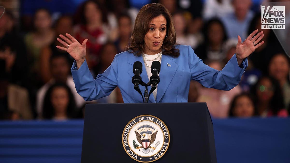 La vicepresidenta Kamala Harris, con un traje azul, se encuentra en el podio.