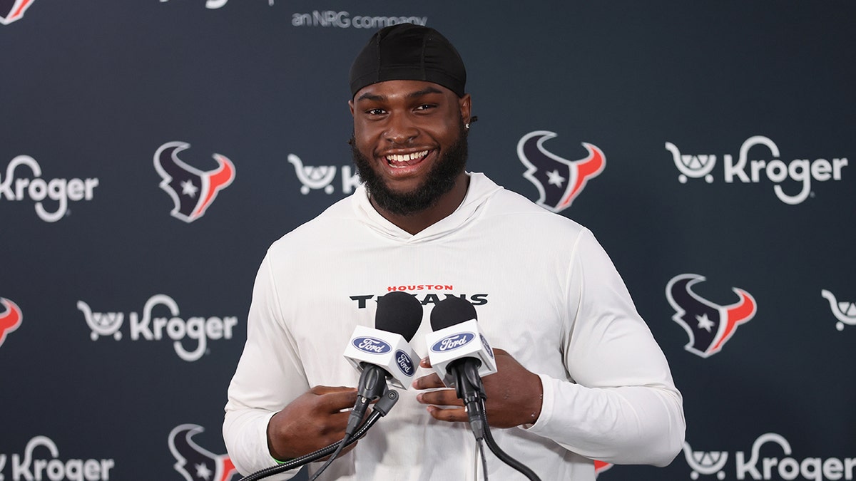 Will Anderson Jr. smiles at lectern