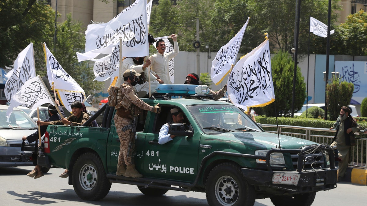 Afghan Taliban riding on green pickup truck