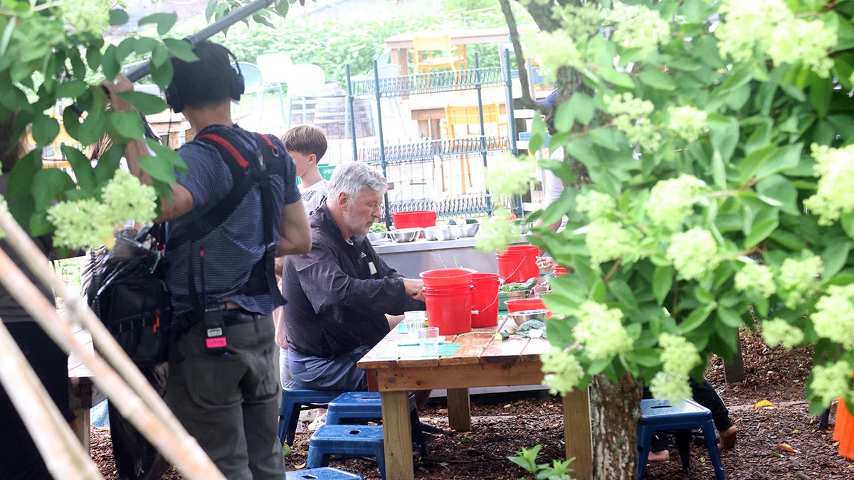 Alec Baldwin looks somber at child's play table in the Hamptons.