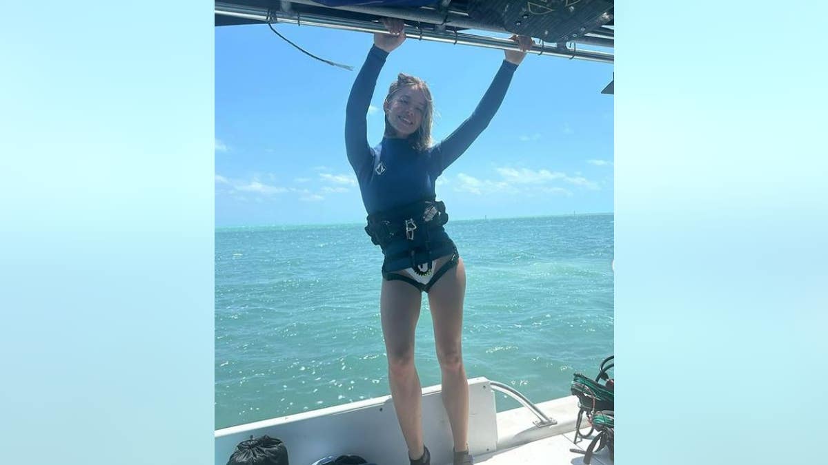 Sydney Sweeney hanging off of a boat