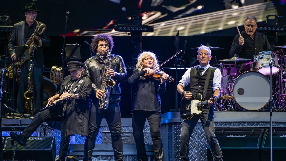 Nils Lofgren, Jake Clemons, and Soozie Tyrell from the E Street Band perform on stage with Bruce Springsteen in Philadelphia