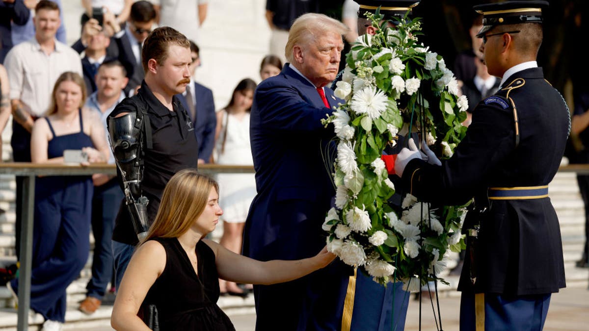 Republican presidential nominee former President Donald Trump lays a wreath alongside Marine Cpl. Kelsee Lainhart (Ret.) and Marine Corps. Sergeant Tyler Vargas-Andrews (Ret.) who were injured at the Abbey Gate Bombing, during a wreath-laying ceremony at the Tomb of the Unknown Soldier at Arlington National Cemetery on Aug. 26, 2024 in Arlington, Virginia.