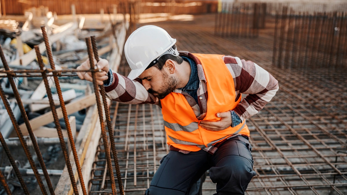 Un trabajador de la construcción con dolor de estómago